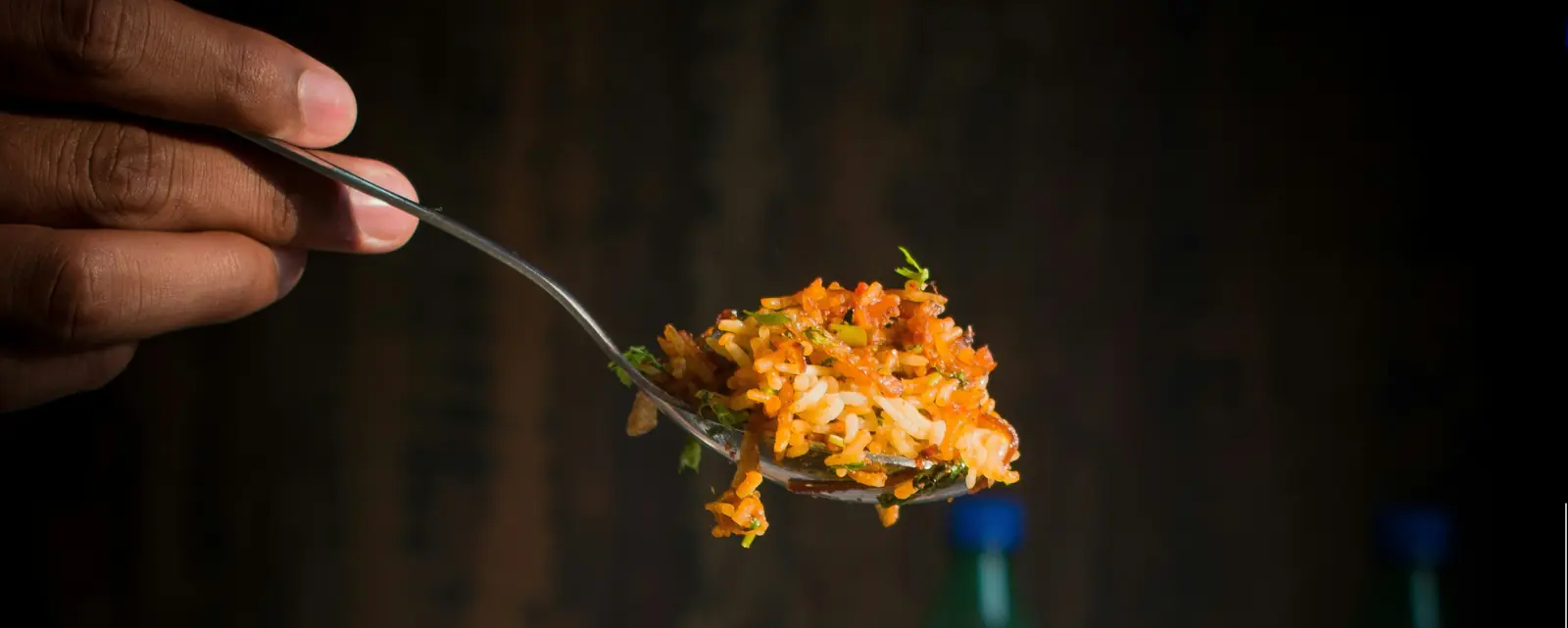 A spoon lifting fragrant biriyani